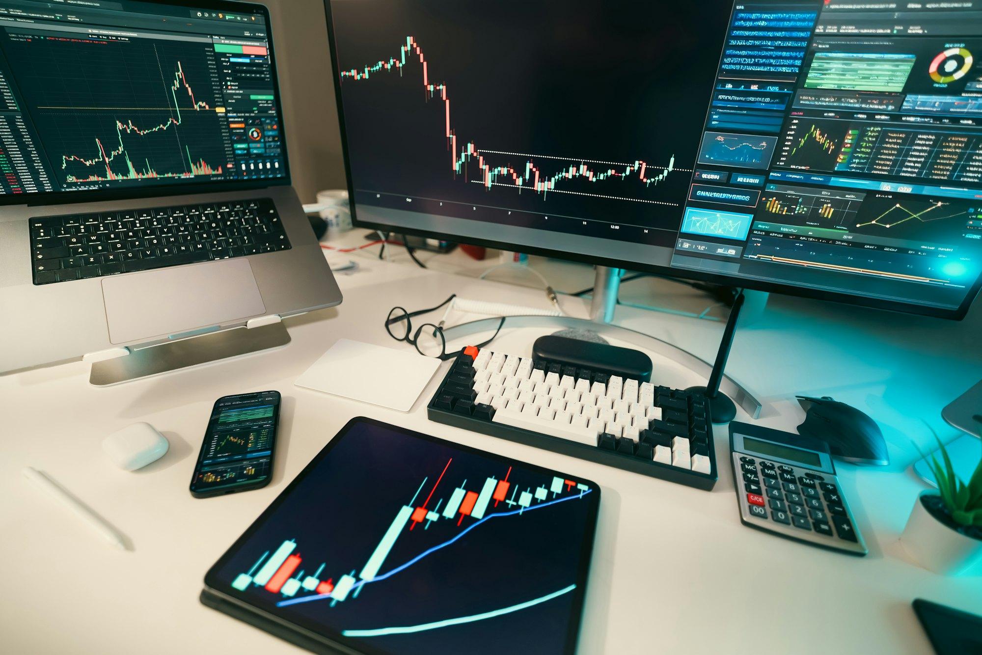 Price charts across several screens on a trading desk.
