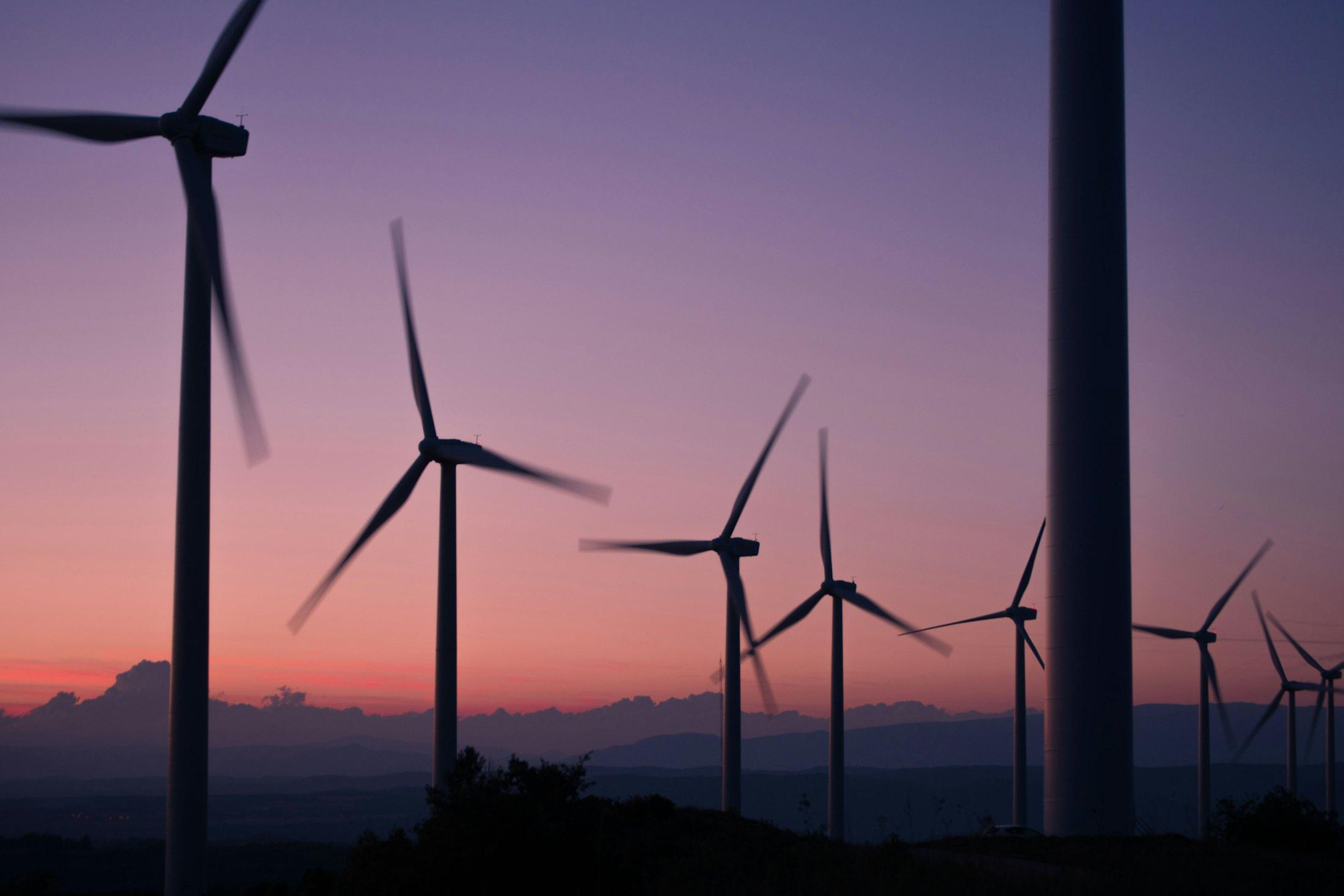 Wind turbines silhouetted against a dusk sky.