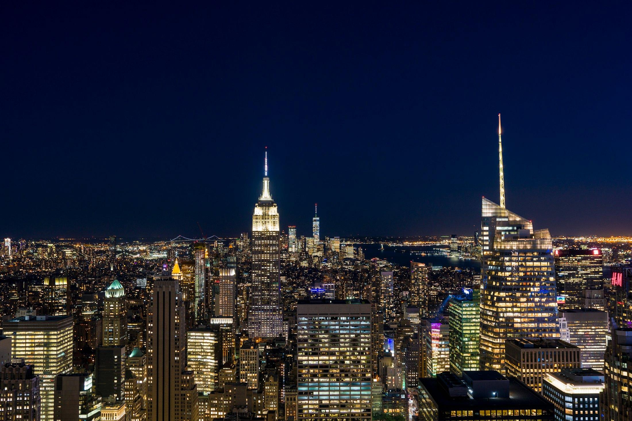 Manhattan at night from above, the Empire State Building lit.