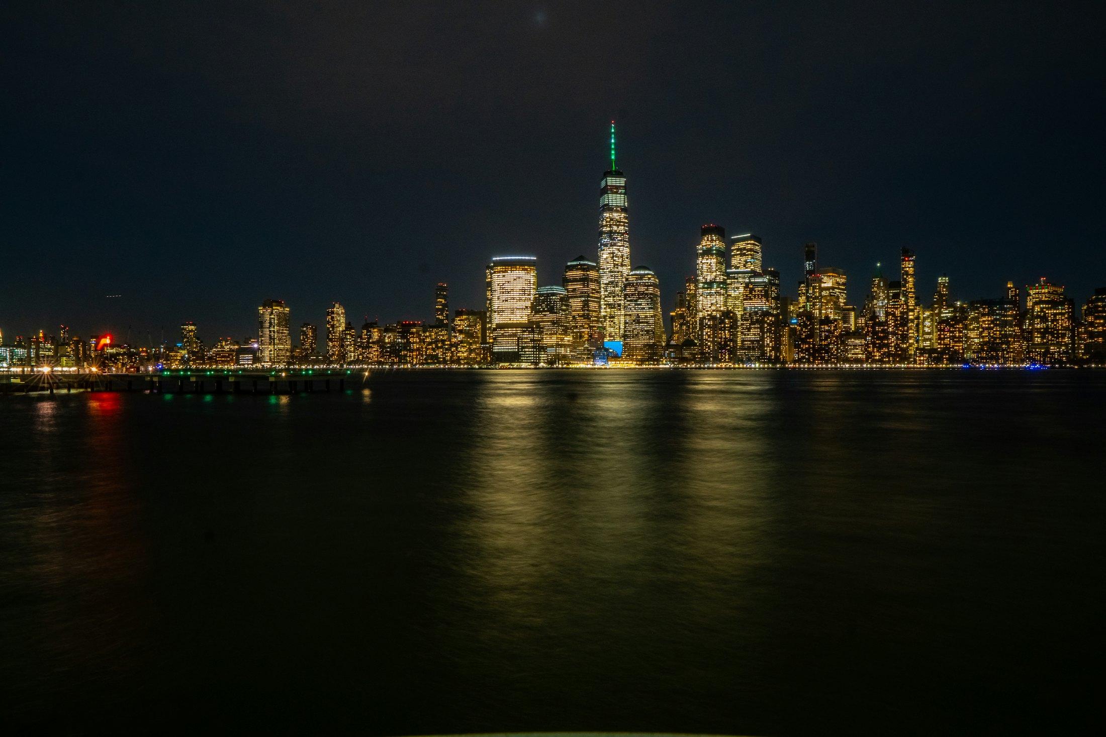 Lower Manhattan at night, seen across the water.